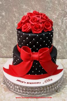 کیک تولد دخترانه قرمز ترکیب با رنگ مشکی و گل و پاپیون فوندانت